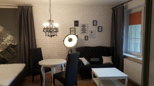 a living room with a couch and a table at Piękna Apartments White in Łomża