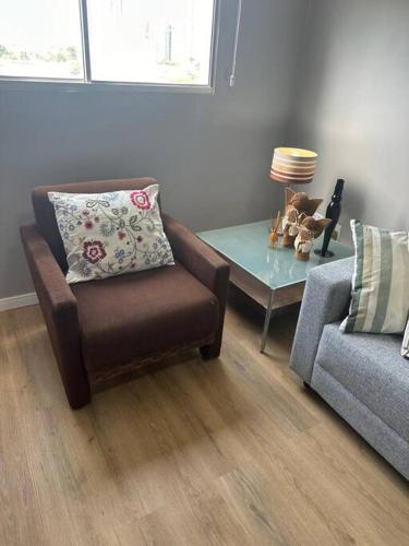 a living room with a chair and a table at Apartamento aconchegante in João Pessoa