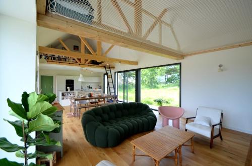 un salon avec un canapé vert et une table dans l'établissement Domaine Sea & Tea, à Plonéour-Lanvern