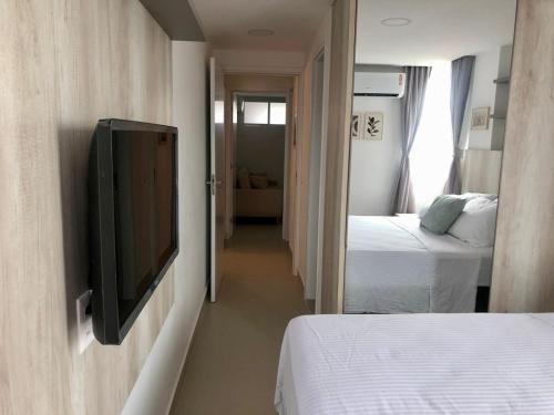 a room with two beds and a flat screen tv at Urban Janeiro - Bessa in Tambaú