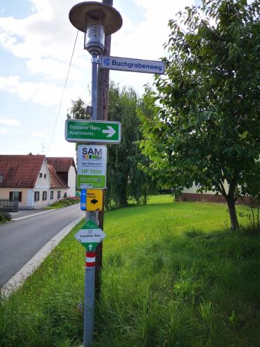 a street sign on a pole with street signs on it at Aparthotel "Goldener Hahn Apartments" in Bad Waltersdorf