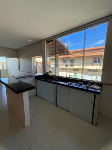 a large kitchen with a large window in a building at Casa 3 quartos 6 pessoas garagem in Coração de Jesus