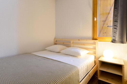 - une chambre avec un lit avec deux oreillers et une fenêtre dans l'établissement Résidence Carene - 2 Pièces pour 5 Personnes 81, à Mâcot La Plagne