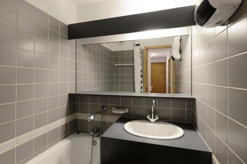 une salle de bain avec un lavabo, un miroir et une baignoire dans l'établissement Résidence Carene - 2 Pièces pour 5 Personnes 81, à Mâcot La Plagne