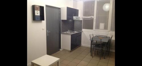 une petite cuisine avec un évier et une table dans l'établissement Studio 11 Malo les bains proche plage, à Dunkerque