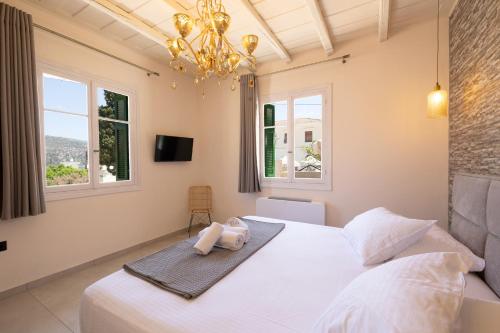 a bedroom with a large white bed with a chandelier at ARCHONTIKO 1922 in Argostoli