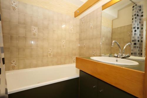 une salle de bain avec un lavabo et une baignoire dans l'établissement Résidence Le Prarion 2 C - Prarion 2 Bât A MAE-6413, aux Houches