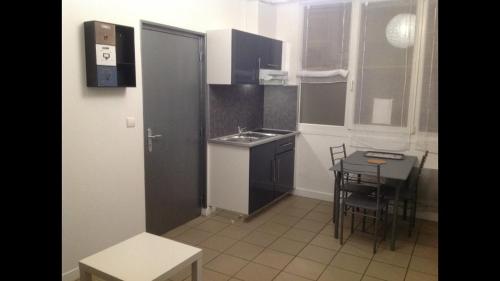 une petite cuisine avec un évier et une table dans l'établissement Studio 11 Malo les bains proche plage, à Dunkerque