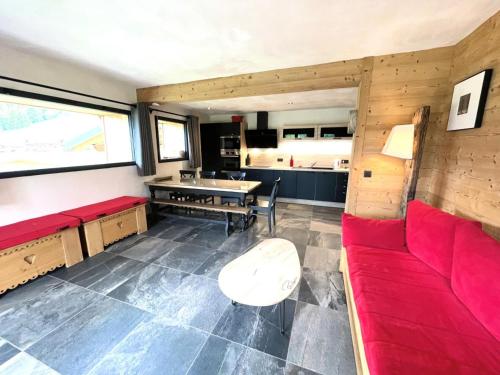 un salon avec un canapé rouge et une cuisine dans l'établissement Résidence La Ferme Du Cheloup - Appartement de charme avec une vue exceptionnelle MAE-2774, à Notre-Dame-de-Bellecombe