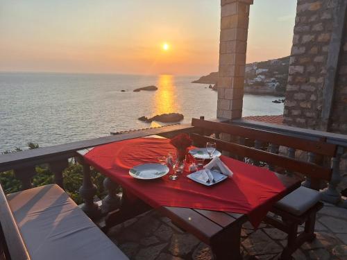 a table with plates and glasses on a balcony with the sunset at Guest house Naser in Ulcinj