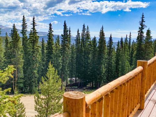 a wooden deck with a view of a forest of trees at Beautiful New Construction Home with Great Views and Pool Table - Silverheels Chalet in Fairplay