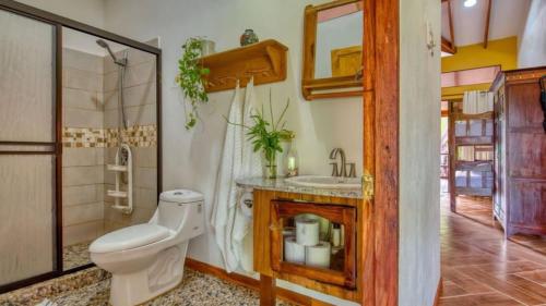 um banheiro com vaso sanitário e pia em Casa jessica em Hone Creek