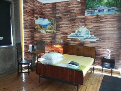 a bedroom with a bed and a wooden wall at Albergue do Visconde in Touguinha