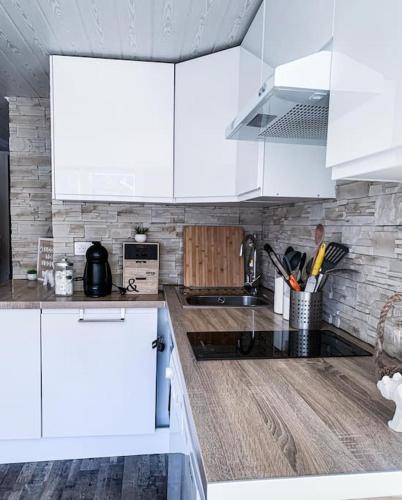 une cuisine avec des armoires blanches et un comptoir dans l'établissement Duplex T3 6,8 pers Vue sur les pistes Isola 2000, à Isola