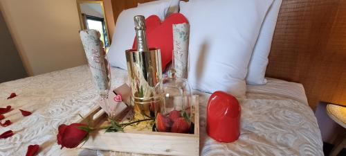a box of champagne and strawberries on a bed at Le Palmier de la Paix in Le Tampon