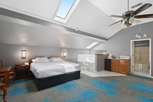 a bedroom with a bed and a bathroom with a ceiling fan at Four Seasons Country Inn in Glasgow