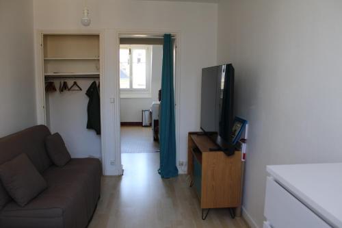 un salon avec un canapé et une télévision à écran plat dans l'établissement Saint-Malo intra, à Saint-Malo