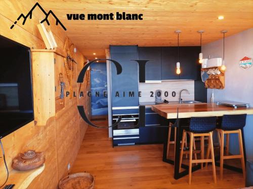 une cuisine avec des armoires bleues et un comptoir avec un îlot dans l'établissement Cozy Luxe 2 étoiles Panorama Imprenable - Paquebot des Neiges - Pied des pistes - Paradiski, à Aime La Plagne