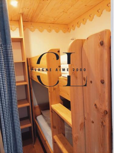 - une chambre avec des lits superposés en bois dans une cabine dans l'établissement Cozy Luxe 2 étoiles Panorama Imprenable - Paquebot des Neiges - Pied des pistes - Paradiski, à Aime La Plagne