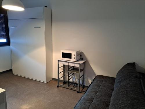 a living room with a couch and a microwave at Joli Studio proche funiculaire in Bourg-Saint-Maurice