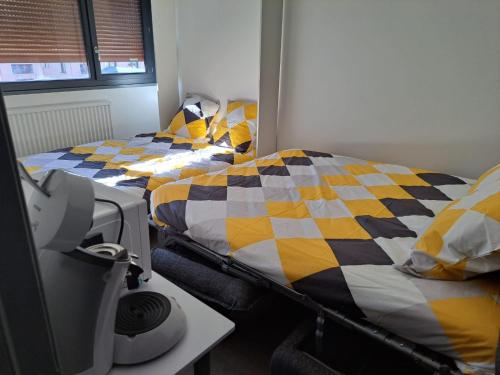 two twin beds in a room with a desk at Joli Studio proche funiculaire in Bourg-Saint-Maurice