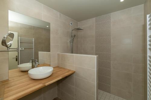 Un baño con lavabo blanco y ducha. en L Arberet 2 village, 4 étoiles, en Vendays-Montalivet