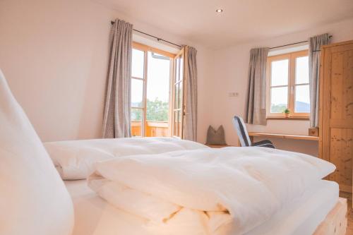 two white beds in a room with a window at zumHofer in Gmund am Tegernsee