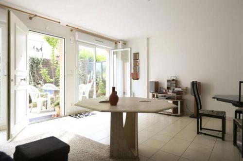 un salon avec une table et une grande fenêtre dans l'établissement Private room in shared house, à Saint-Ouen