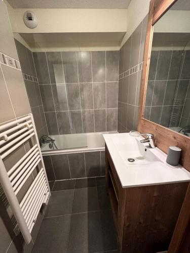 une salle de bain avec un lavabo et une baignoire dans l'établissement Résidence Le Hameau Des Rennes - LE HAMEAU DES RENNES MAE-0051, à Vars