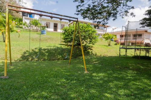 a park with a swing set in the grass at Lago Calima - Bella Finca in Madroñal