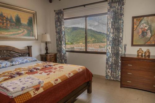 a bedroom with a bed and a large window at Lago Calima - Bella Finca in Madroñal
