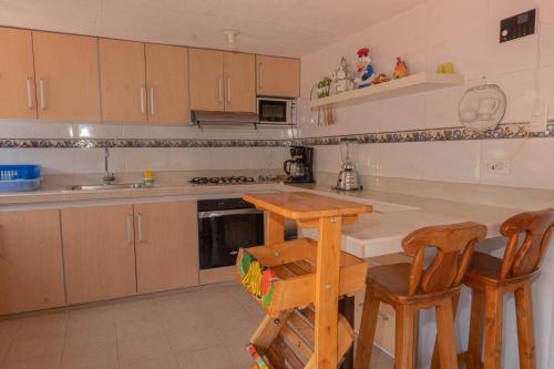 a kitchen with wooden cabinets and a table and chairs at Lago Calima - Bella Finca in Madroñal