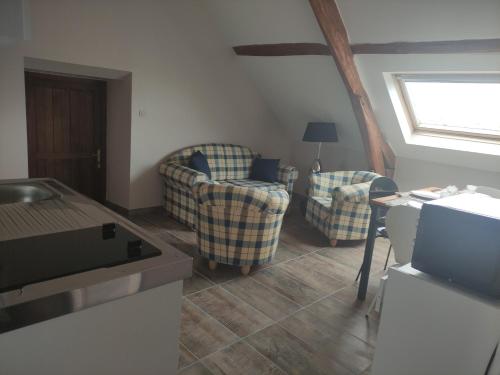 a living room with two chairs and a table at Autour des lacs in Hommes