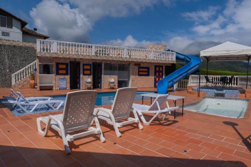 a pool with a slide and chairs and a playground at Lago Calima - Bella Finca in Madroñal