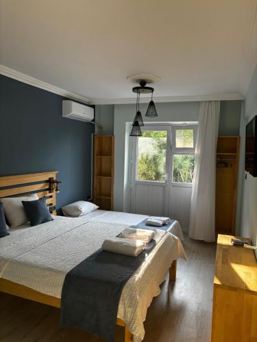 a bedroom with a large bed and a window at Gökçeada Helios Pansiyon in Gokceada Town