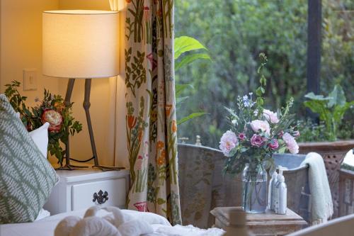 a vase of flowers on a table next to a window at Mukima Manor in Nanyuki