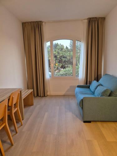 a living room with a couch and a window at Hotel Levante in Es Pujols
