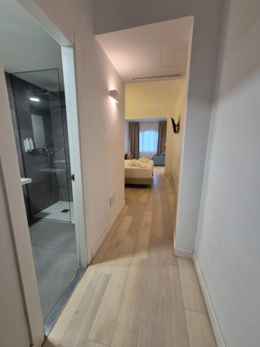 a hallway leading to a bathroom with a glass door at Hotel Levante in Es Pujols