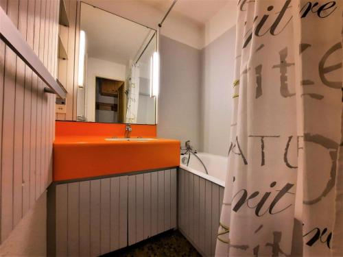 La salle de bains est pourvue d'un lavabo orange et d'un miroir. dans l'établissement Résidence Chaviere - Studio 4 pers à la Croisette - vue sur les pistes - accès 3 Vallées MAE-5464, aux Menuires