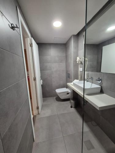 a bathroom with a sink and a toilet at Hotel Levante in Es Pujols