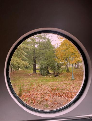 a round window with a view of a park at Quinta Santo Antonio do Rio in Celorico da Beira