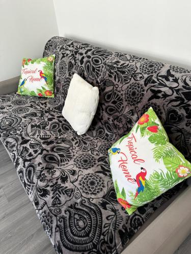 - un canapé noir et blanc avec 2 oreillers dans l'établissement Un petit coin de paradis, à Fort-Mahon-Plage