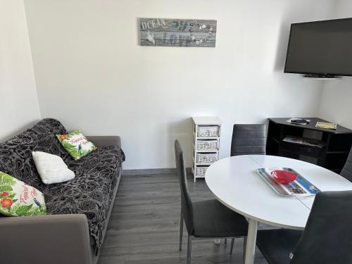 un salon avec un canapé et une table dans l'établissement Un petit coin de paradis, à Fort-Mahon-Plage