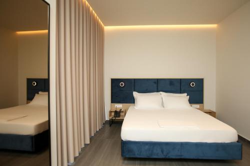 a bedroom with two beds and a mirror at ReiVal Hotel Marina Vlore in Vlorë