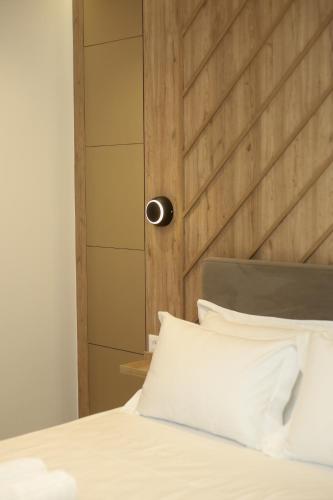 a bed with a wooden headboard and white pillows at ReiVal Hotel Marina Vlore in Vlorë