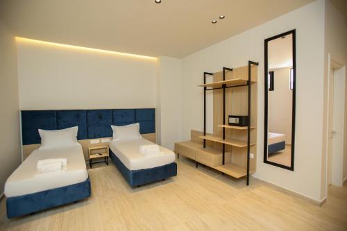 a small room with two beds and a mirror at ReiVal Hotel Marina Vlore in Vlorë