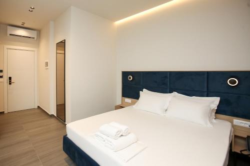 a bedroom with a large white bed with two towels at ReiVal Hotel Marina Vlore in Vlorë