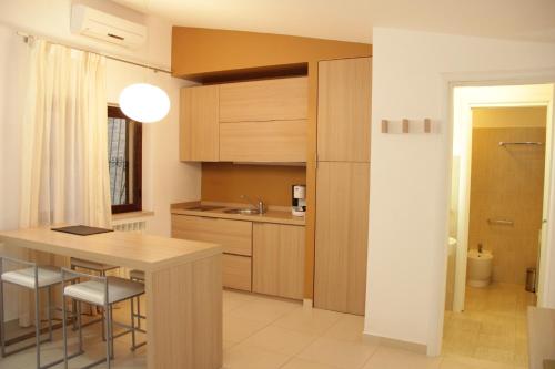 a kitchen with wooden cabinets and a table with stools at San Michele Apartments&Rooms in Catanzaro