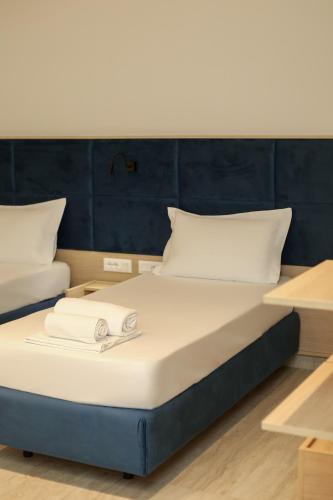 a bed with white sheets and pillows on it at ReiVal Hotel Marina Vlore in Vlorë