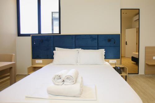 a bedroom with a white bed with towels on it at ReiVal Hotel Marina Vlore in Vlorë